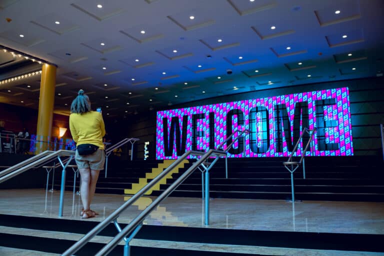 Woman taking picture of large LED Welcome sign