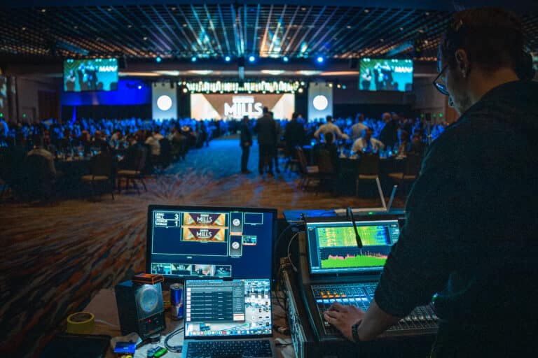 Behind computers with Sherwin Williams stage in front