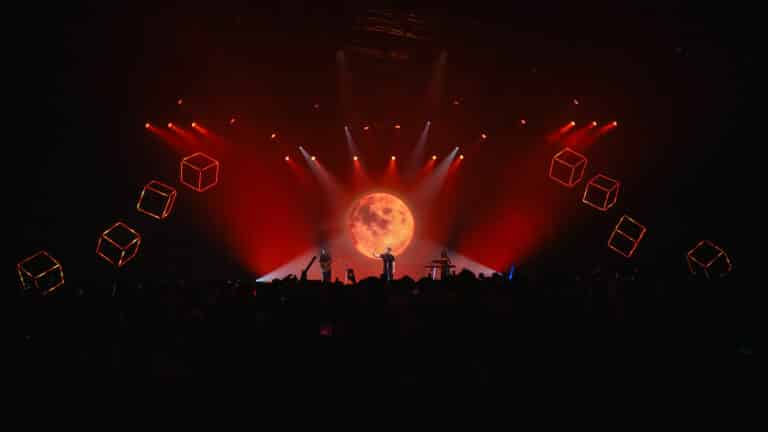 Alex Warren performing at the 2025 Forbes Under 30 Summit in front of lighting designed by Colortone